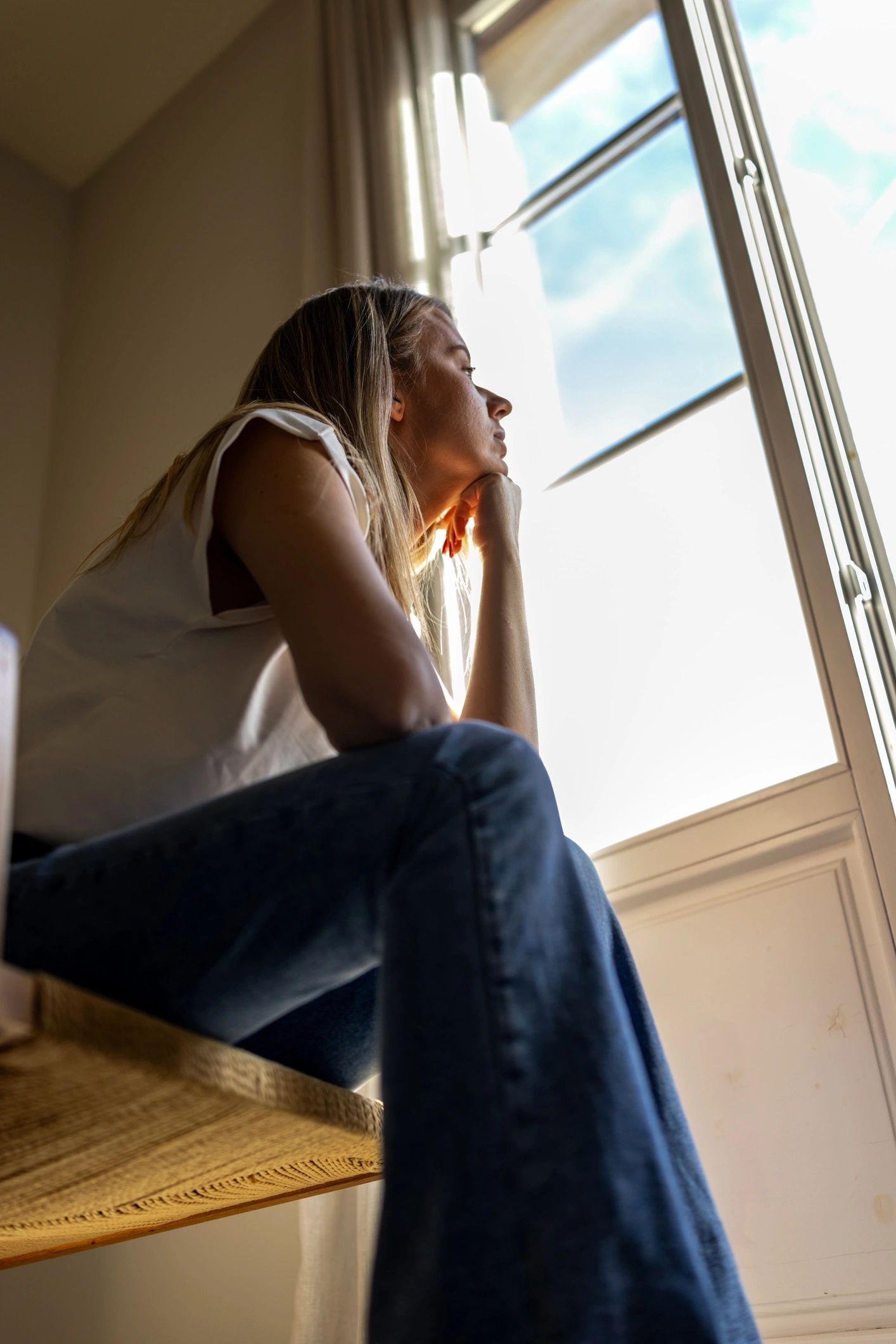 Contemplative figure seated by a sunlit window