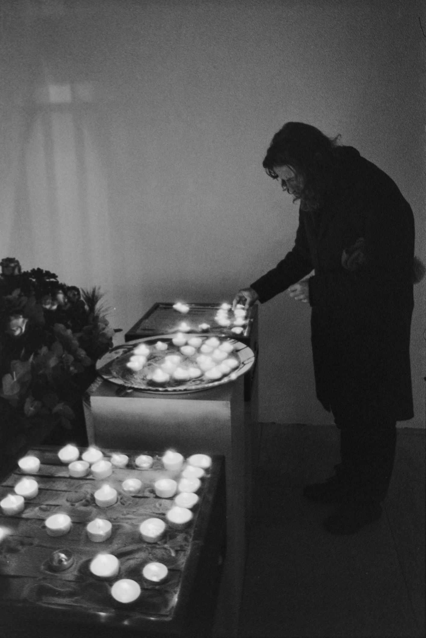 Person lighting memorial candles